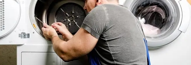 Dryer repair technician fixing a clothes dryer drum in Bloomington, IN