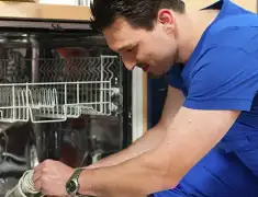 Dishwasher repair technician inspecting and servicing an open dishwasher in Bloomington, IN