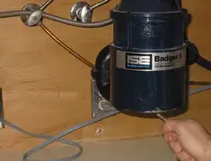 Garbage disposal repair technician tightening the mounting ring under a sink in Bloomington, IN