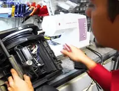 Vacuum repair technician servicing internal components on a workbench in Bloomington, IN