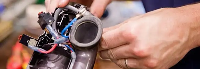 Vacuum repair technician reconnecting wiring and components in Bloomington, IN