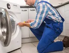 Washing machine repair technician servicing a front-load washer in Bloomington, IN