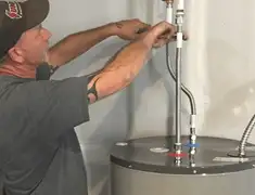 Water heater repair technician tightening supply line connections in Bloomington, IN